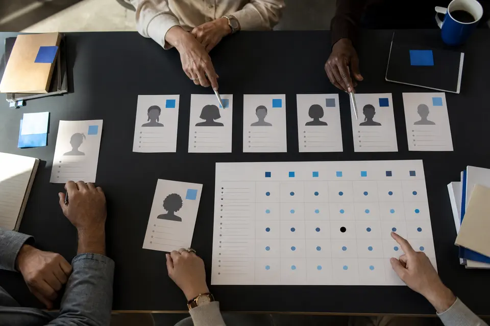 Équipe examinant des candidatures anonymisées à l’aide d’une grille de critères commune.